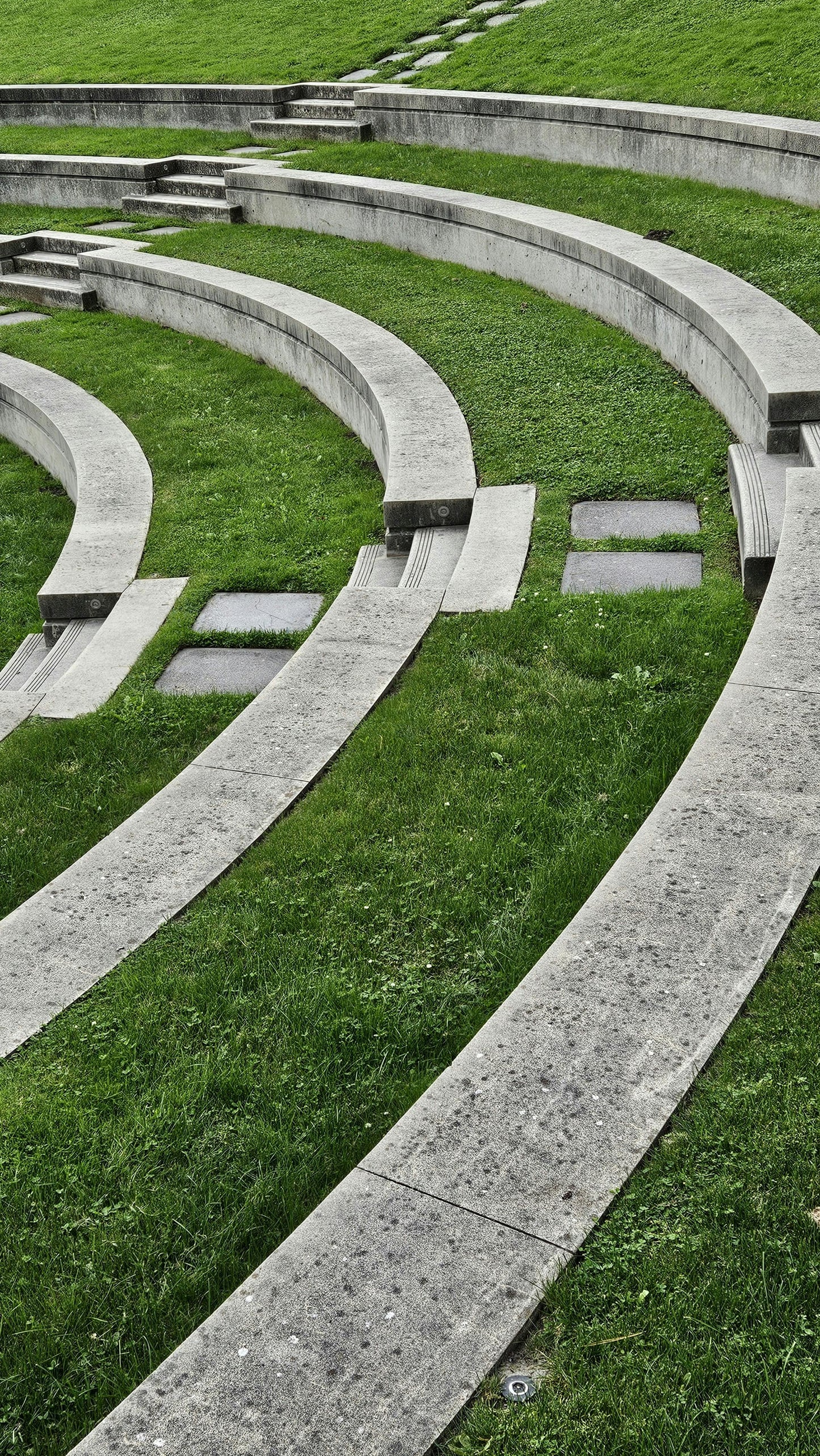 Concrete steps and seating area with grass in a park-like setting